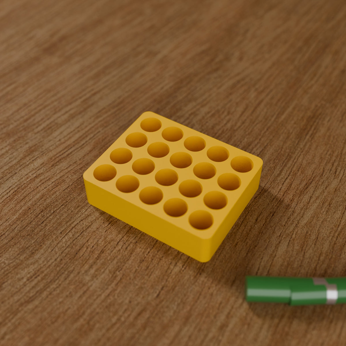 Battery Organizer (20x AA) in Bright Yellow PLA, next to batteries on a wooden workbench
