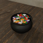 Cauldron Candy Dish in Matte Black PLA, filled with wrapped candy on a dark wooden table