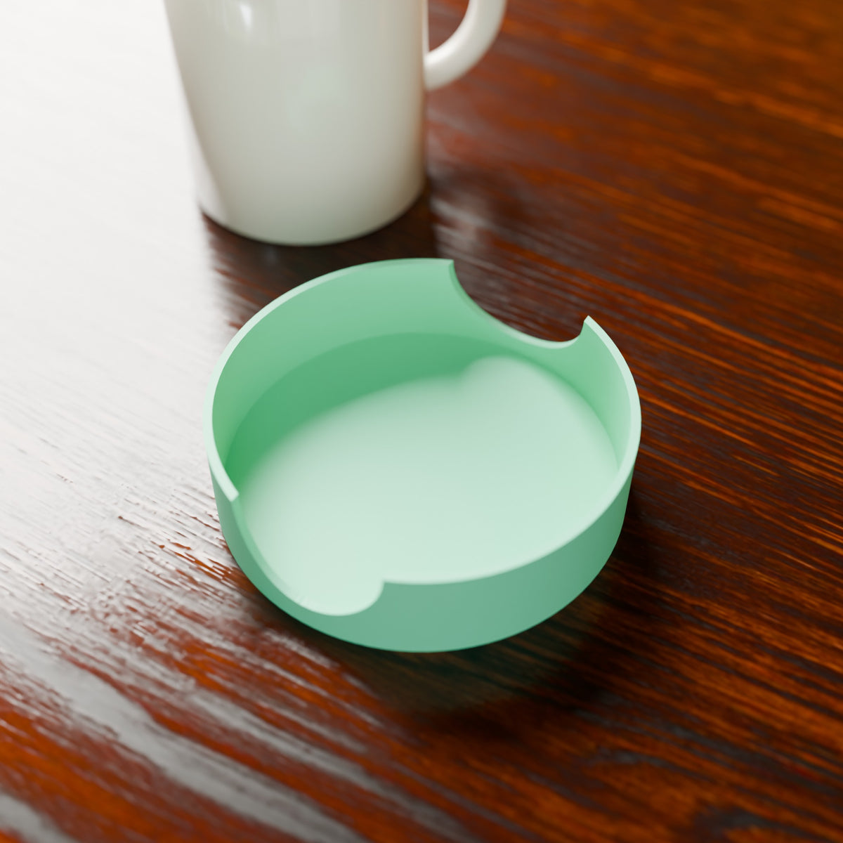 Coaster Caddy in Matte Mint PLA, next to a coffee mug on a wooden table