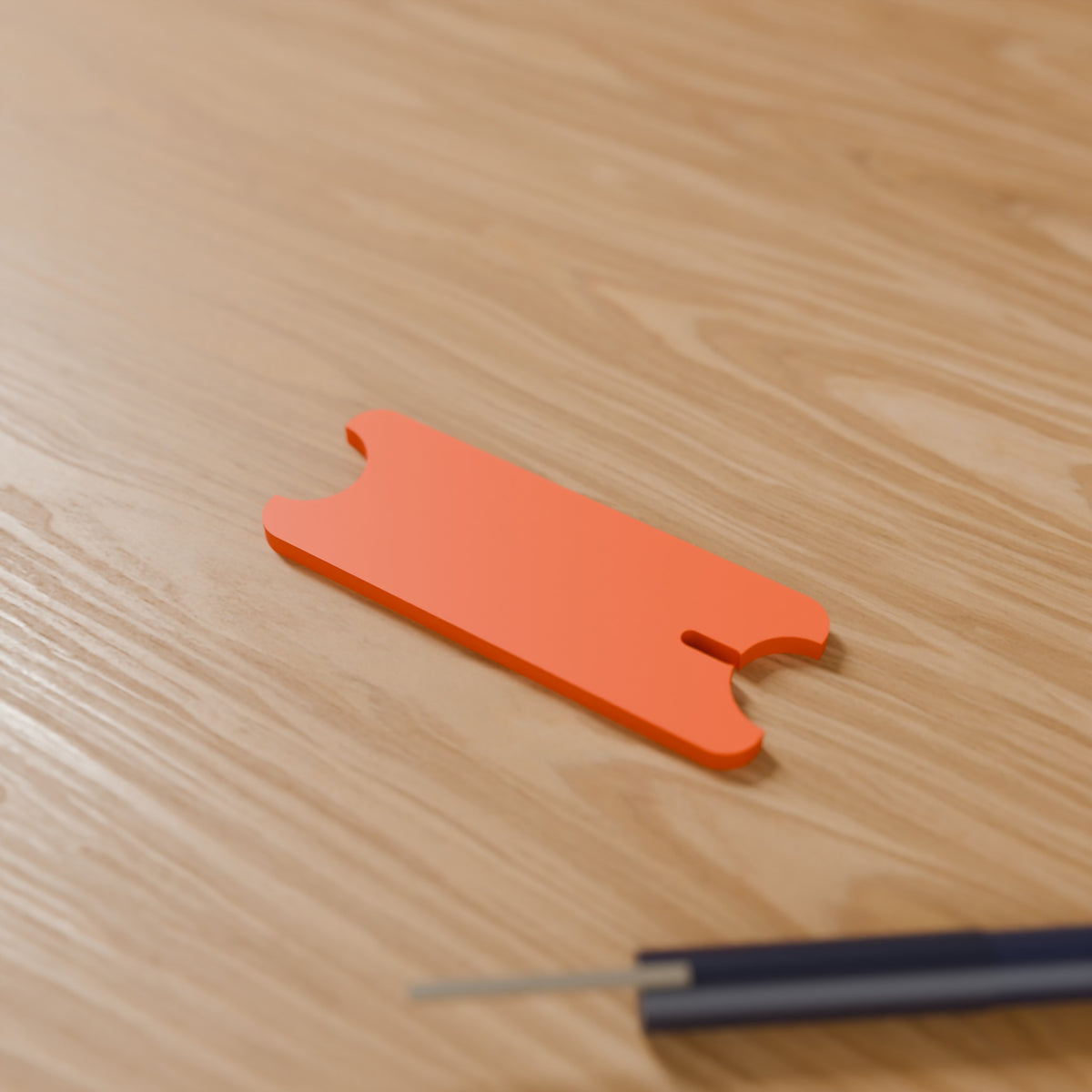 Cord Wrap Winder (Large, laptop charger) in Bright Orange PLA, on a wooden desk