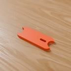 Cord Wrap Winder (Small, earbuds) in Bright Orange PLA, on a wooden desk