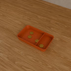 Desk Catch-All Tray in Matte Terracotta PLA, holding coins on a wooden desk