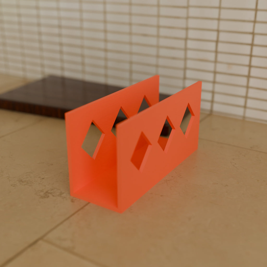 Diamond Napkin Holder in Matte Coral PLA, on a kitchen counter