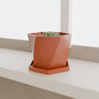 Geometric Planter with Saucer in Matte Terracotta PETG, with a succulent on a windowsill