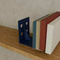 Modern Bookends (Pair) in Matte Navy PLA, holding books on a wooden shelf