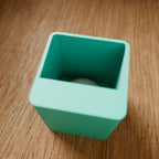 Modular Storage Bin (1x1) in Matte Teal PLA, on a wooden surface