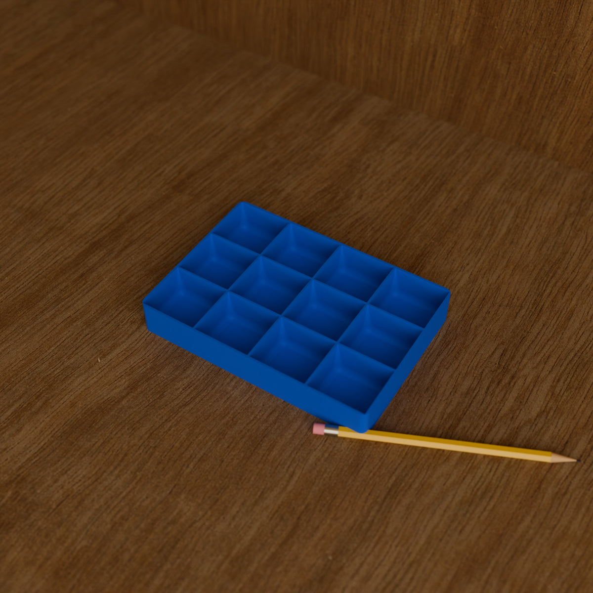 Screw & Parts Sorting Tray in Bright Blue PLA, next to a pencil on a wooden workbench