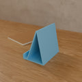 Tablet Stand in Matte Sky Blue PLA, on a wooden desk