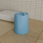 Toothbrush & Paste Holder in Matte Sky Blue PETG, on a bathroom counter