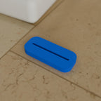 Tube Squeezer in Bright Blue PLA, on a bathroom counter