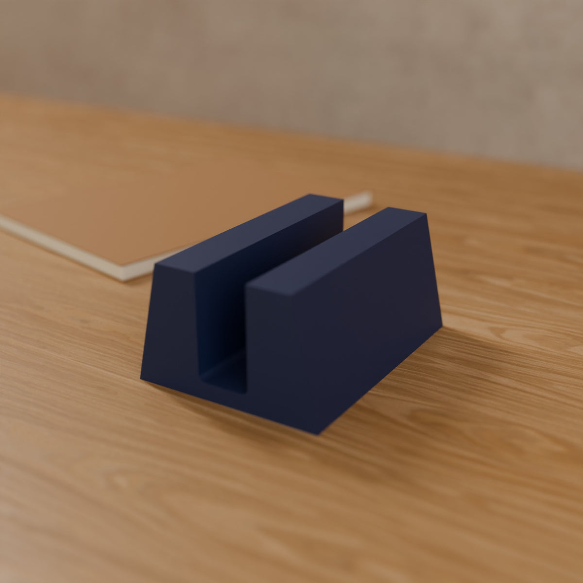 Vertical Laptop Stand (Slot 24 mm) in Matte Navy PLA, on a wooden desk