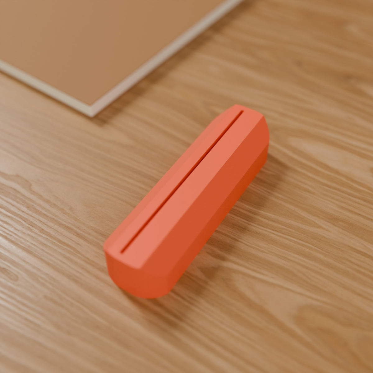 Wave Photo & Postcard Stand in Matte Coral PLA, on a wooden desk